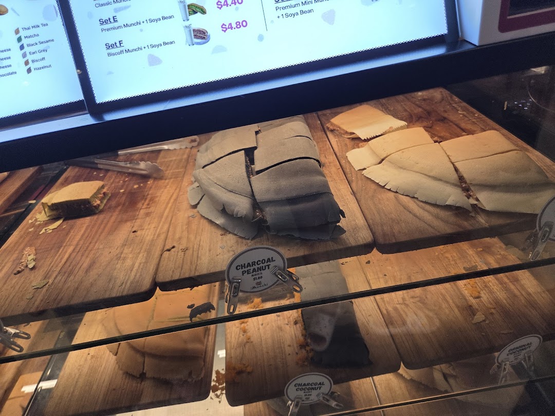 A display case at Munchi Pancakes showcasing various pancake flavors and a digital menu.