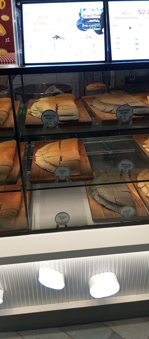 A display case showcasing various sliced Munchi Pancakes, including green tea, charcoal, and original flavors.