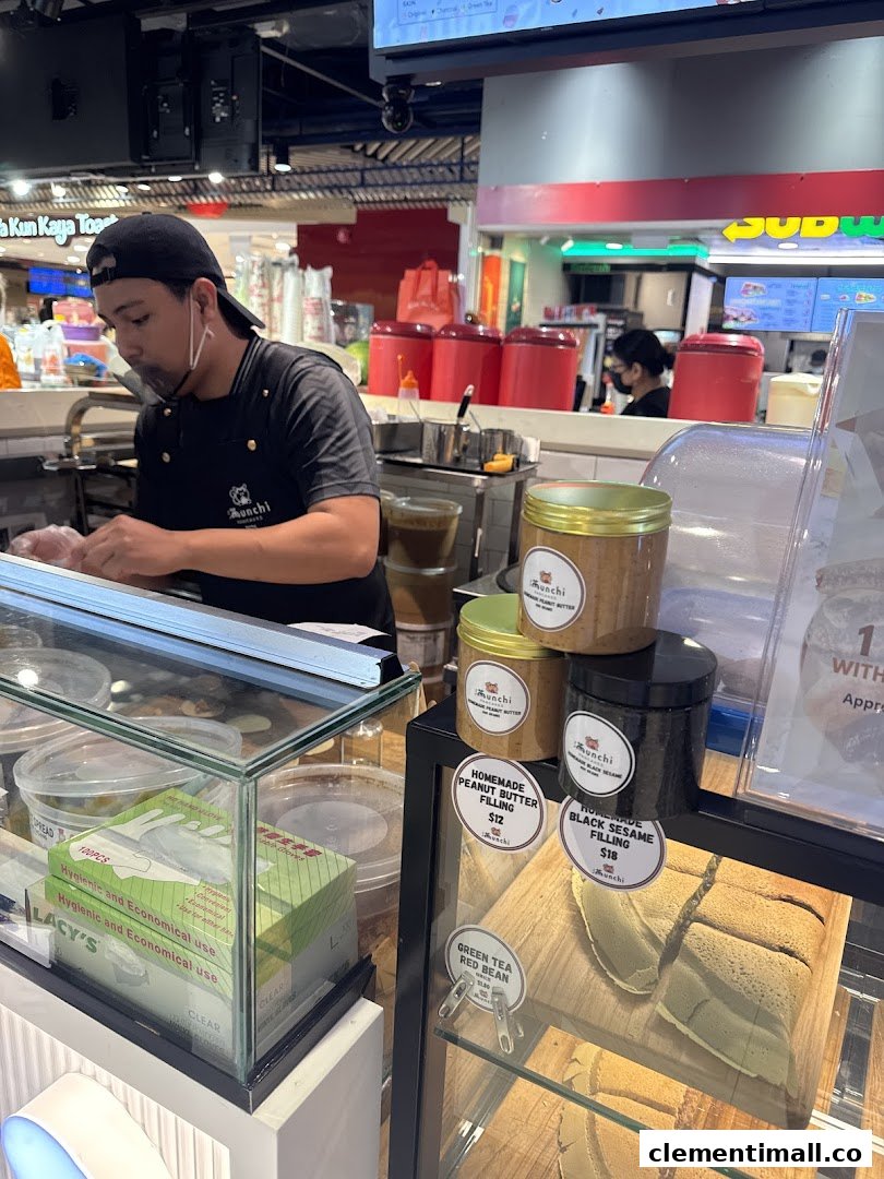 A staff member at Munchi Pancakes prepares fresh items, showcasing delicious pancake fillings and products.