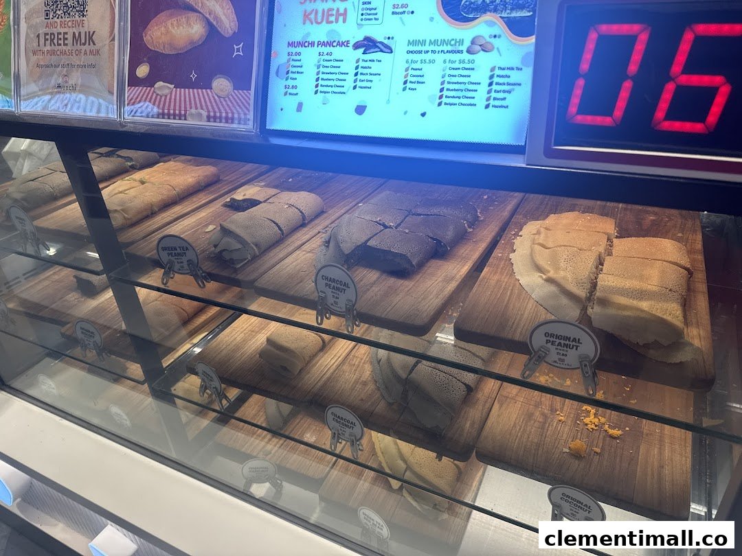 A vibrant display of Munchi Pancakes in a glass case, with a digital menu board showcasing various flavors and prices.