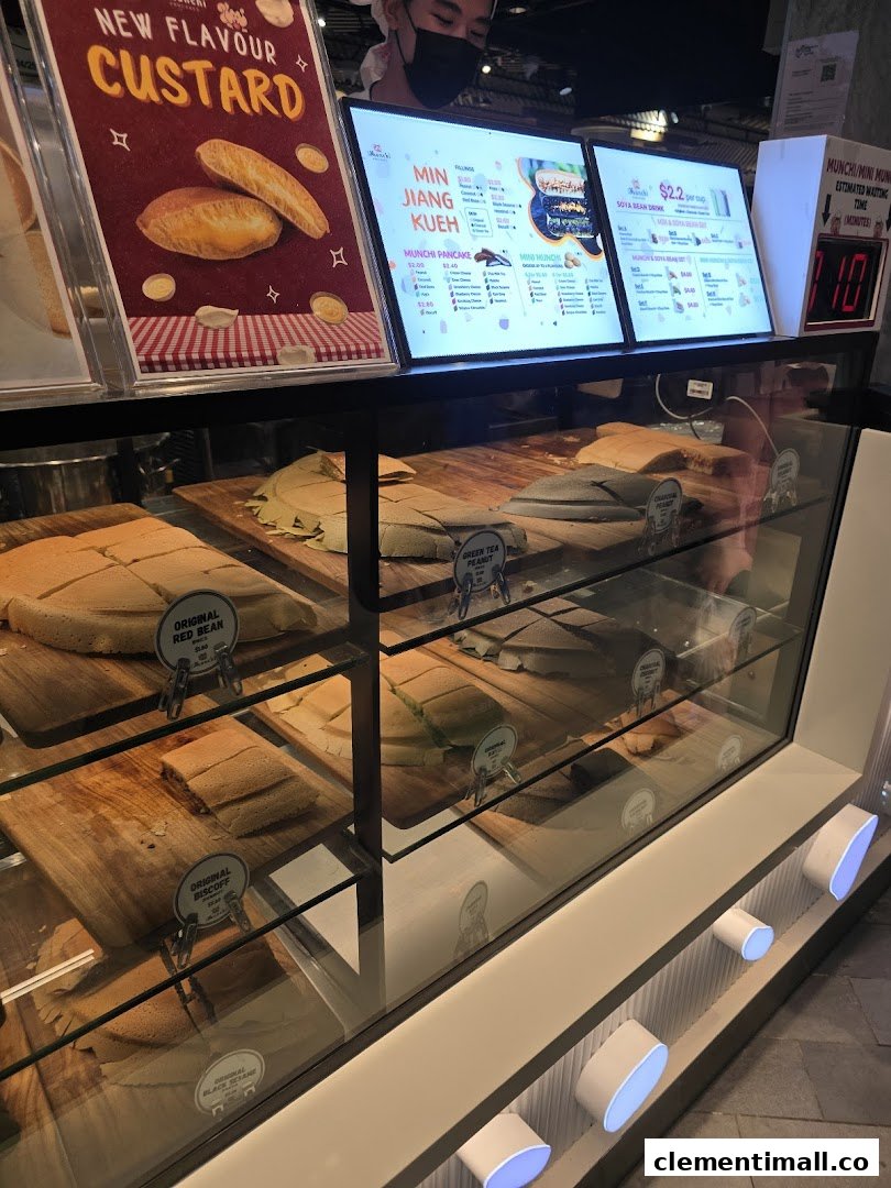 A vibrant display of freshly made Munchi Pancakes and digital menu boards showcasing various flavors and drinks.