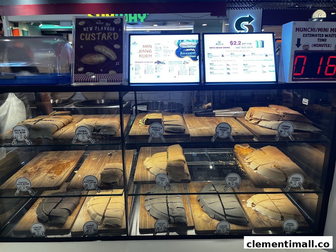 A vibrant display counter showcasing various Munchi Pancakes and digital menu boards with prices.