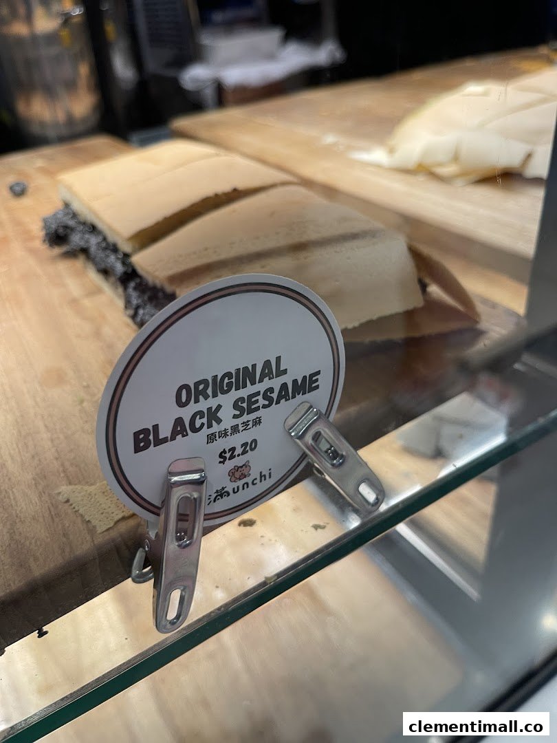 A close-up of Munchi Pancakes' Original Black Sesame pancake with its price tag on a wooden display.