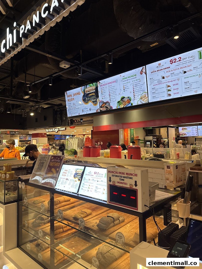 A vibrant view of Munchi Pancakes' counter, showcasing fresh pancakes, digital menus, and a waiting time display.