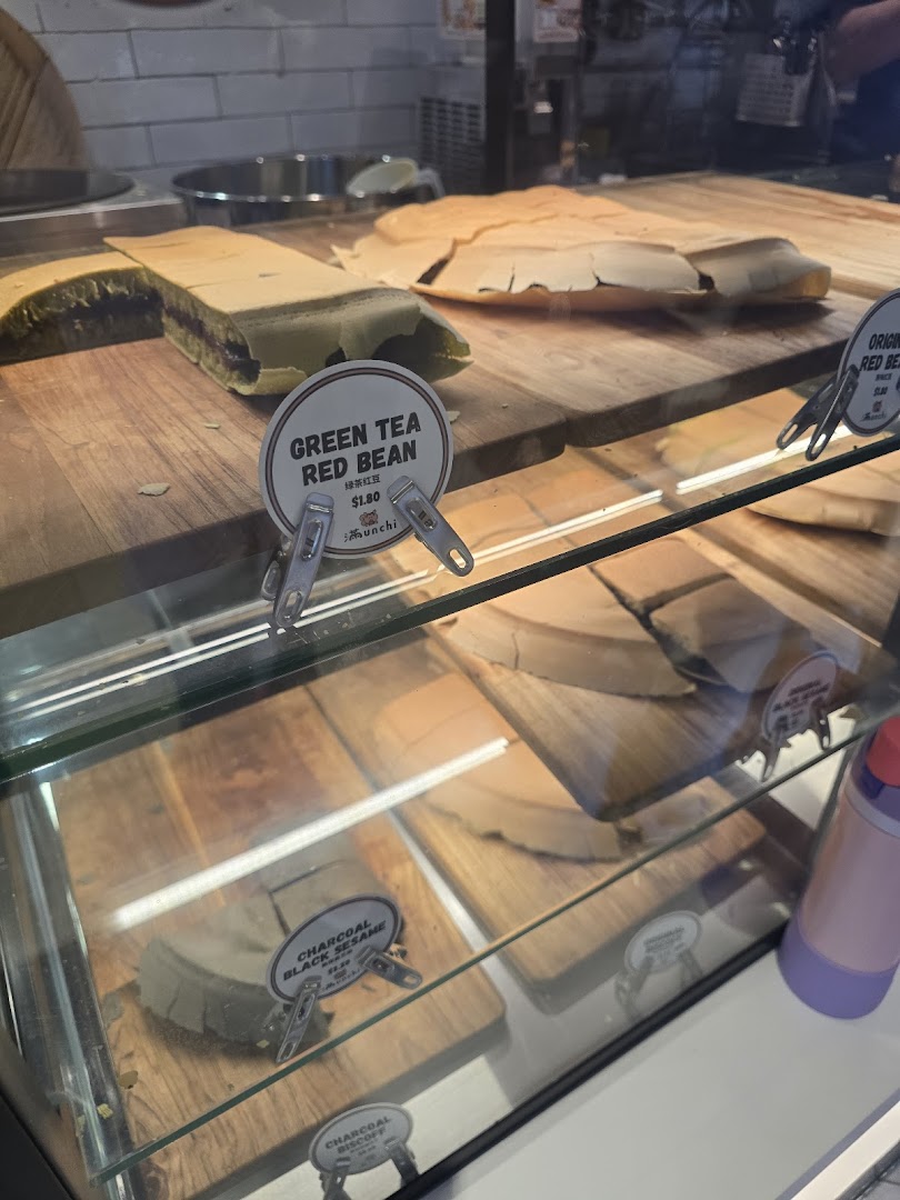A display case showcasing various Munchi Pancakes, including Green Tea Red Bean and Charcoal Black Sesame.