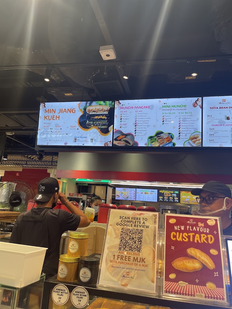 A vibrant digital menu board at Munchi Pancakes showcasing various pancake and dessert options.
