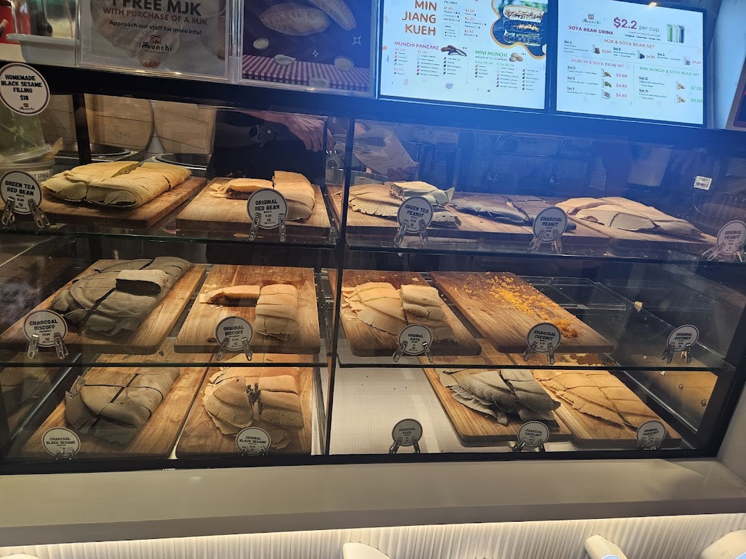 A display case showcasing various traditional pancakes with digital menu boards detailing flavors and prices.