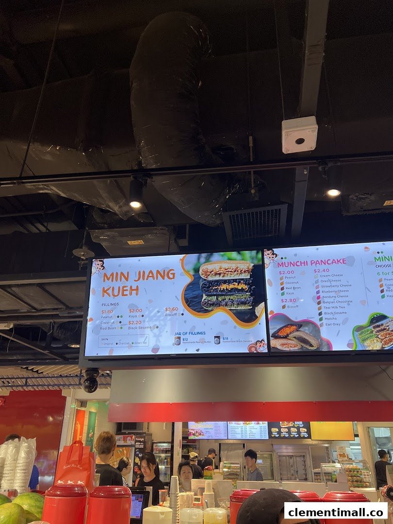 A digital menu board displaying various pancake and kueh options with prices at Munchi Pancakes.