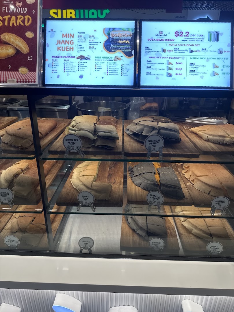 A display case showcasing various pancakes with digital menu boards listing flavors and prices.