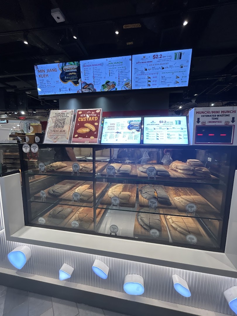 A vibrant display counter showcasing various pancakes and digital menu boards with prices and offerings.