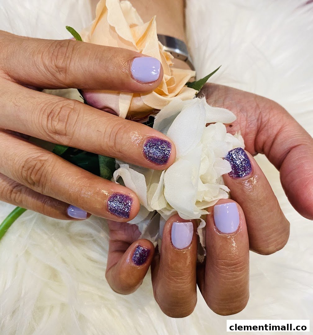 Close-up of hands showcasing a fresh manicure with purple glitter and lavender nail polish.
