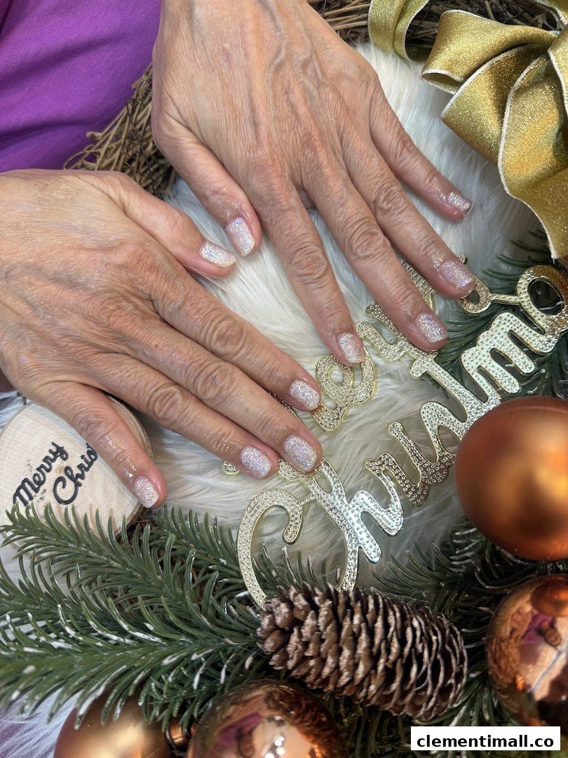 Close-up of hands with sparkling glitter nails amidst festive Christmas decorations, showcasing a manicure.
