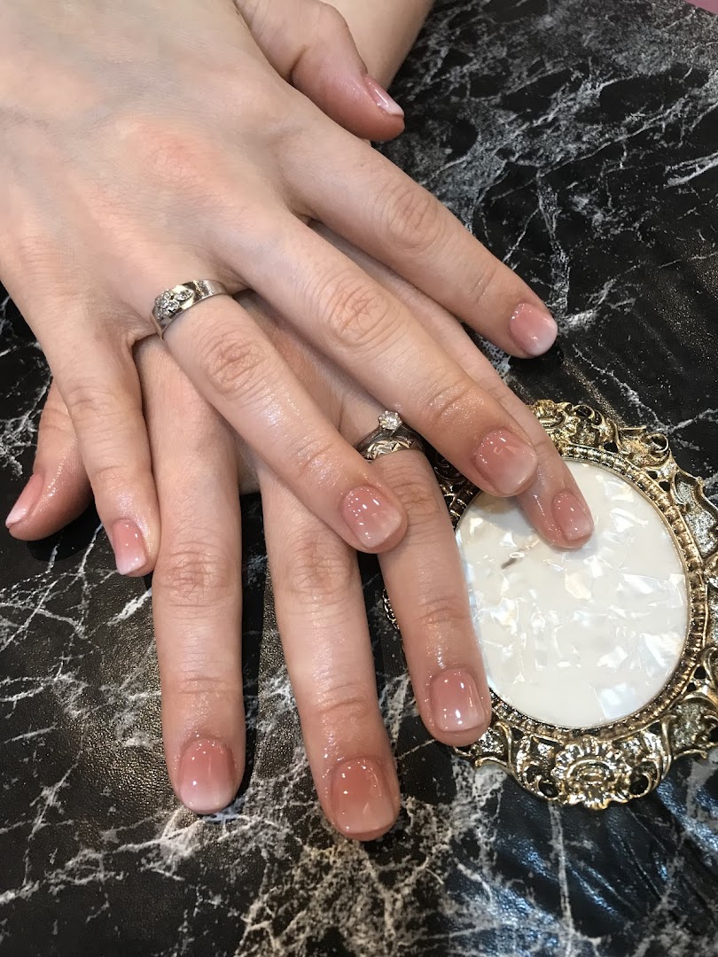Close-up of hands showcasing a fresh, elegant ombre manicure with a glossy finish.
