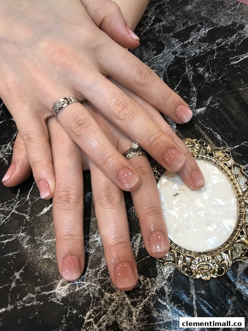 Close-up of hands showcasing a fresh, elegant ombre manicure with a glossy finish.