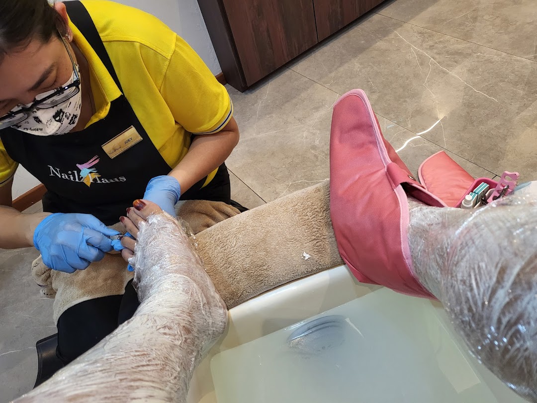 A Nailz Haus technician performs a foot treatment on a client, showcasing a relaxing pampering session.