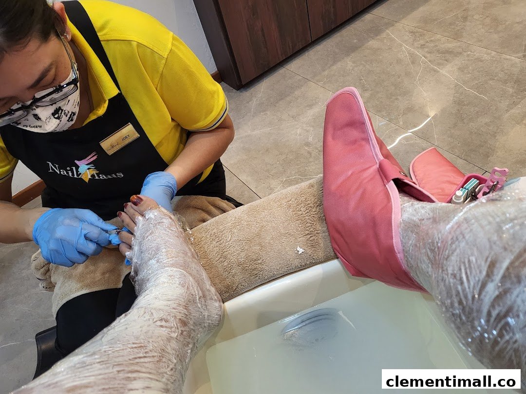 A Nailz Haus technician performs a foot treatment on a client, showcasing a relaxing pampering session.