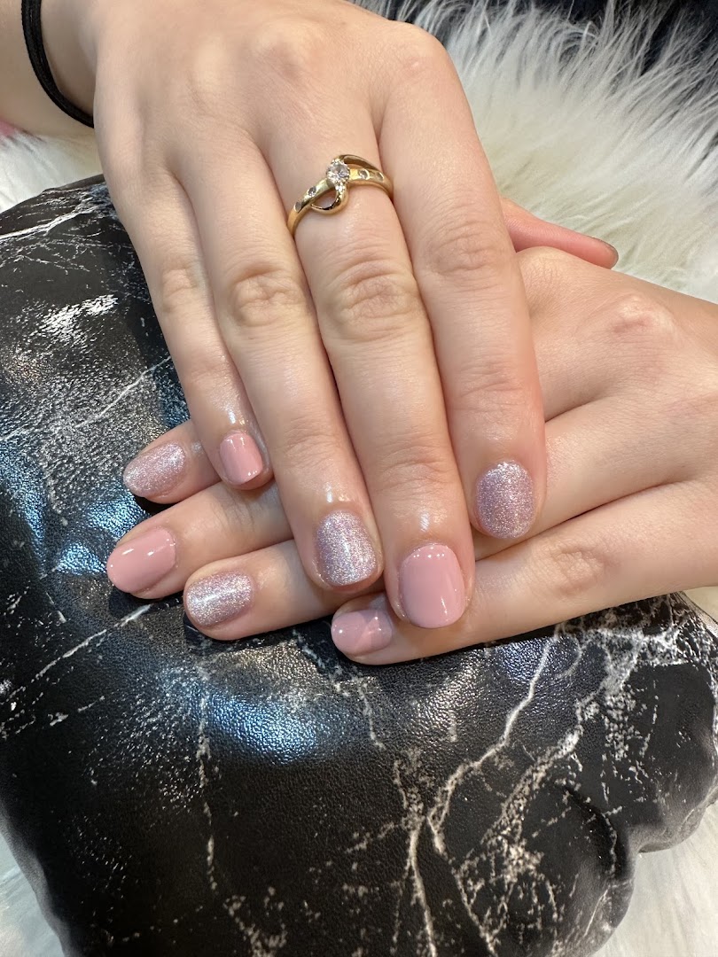 Close-up of hands with a fresh manicure featuring pink and glitter nail polish.