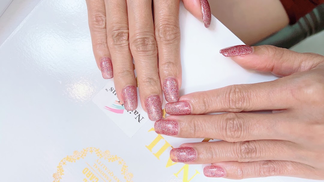 Close-up of hands showcasing sparkling pink glitter nail polish, highlighting a professional manicure service.
