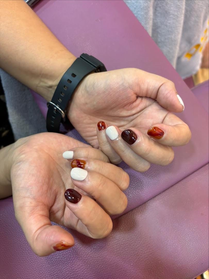 Close-up of hands showcasing a stylish, multi-colored nail art design.