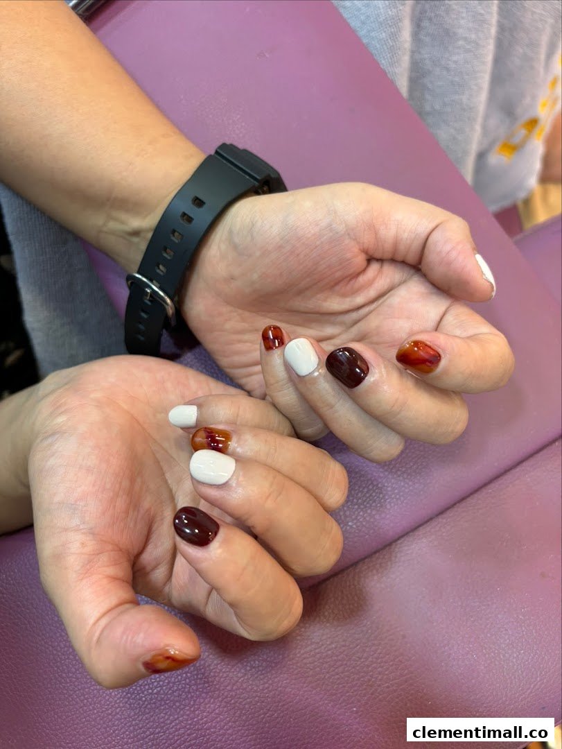 Close-up of hands showcasing a stylish, multi-colored nail art design.
