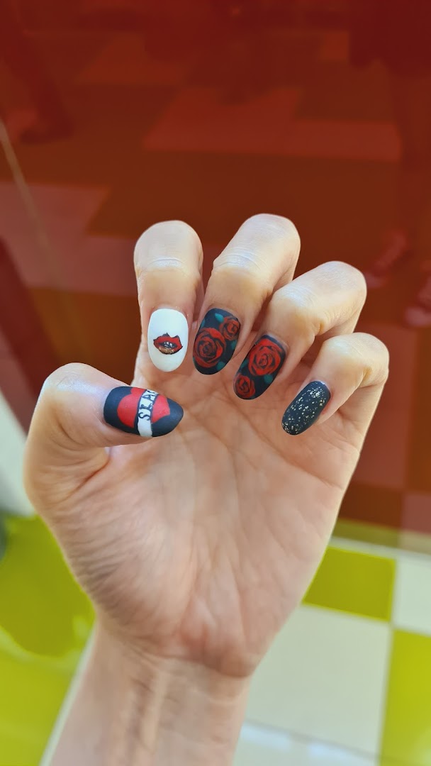 Close-up of a hand showcasing custom nail art with rose, lip, and glitter designs.