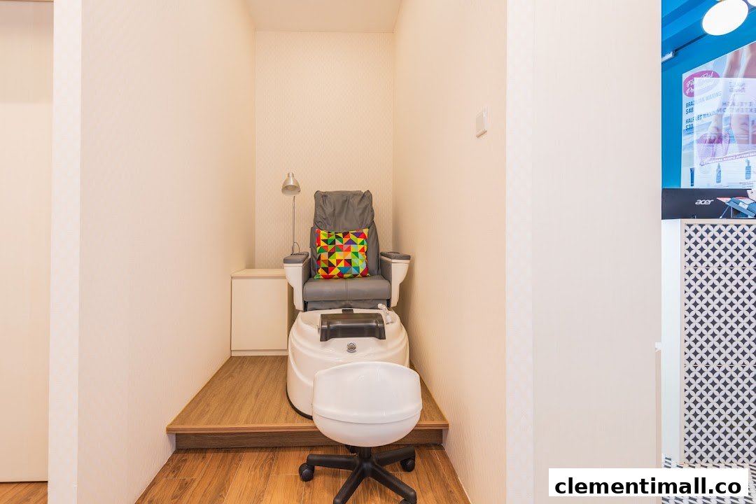 A comfortable pedicure station with a grey chair, foot spa, and colorful cushion.