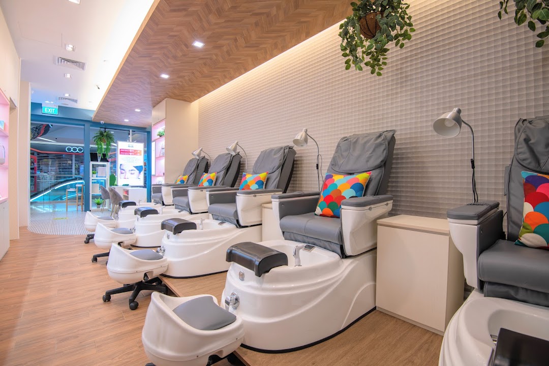 A modern nail salon interior featuring multiple comfortable pedicure chairs with foot basins.