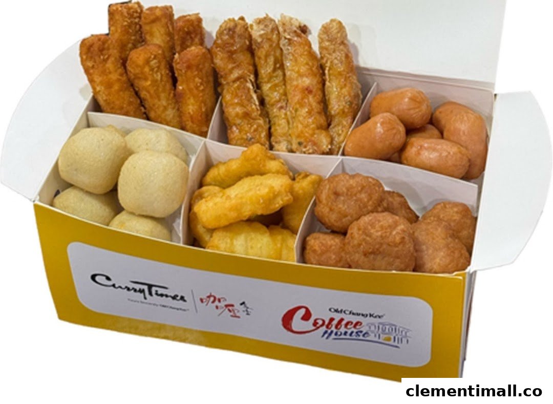 A white and yellow box filled with various fried snacks, including fish balls, sausages, and spring rolls.
