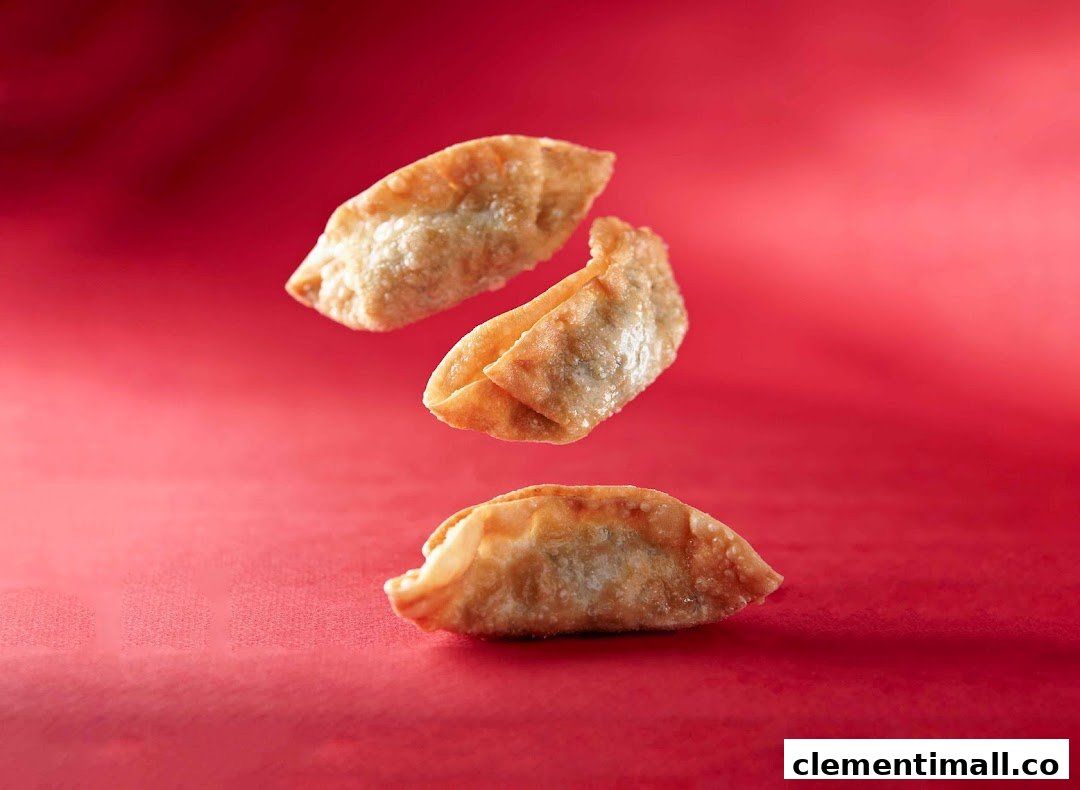 Three golden-fried dumplings float against a vibrant red background, showcasing a delicious snack.