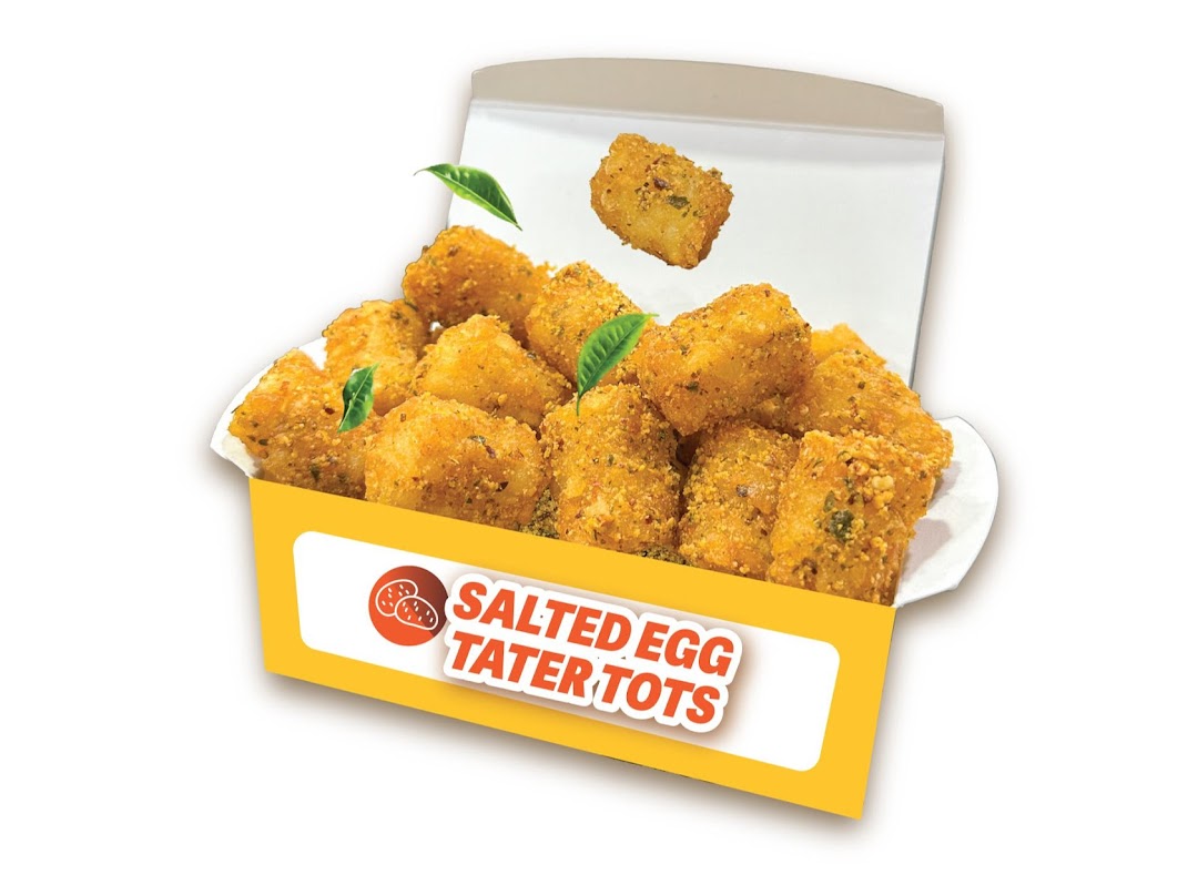 A vibrant image of golden-brown salted egg tater tots in a yellow and white box.