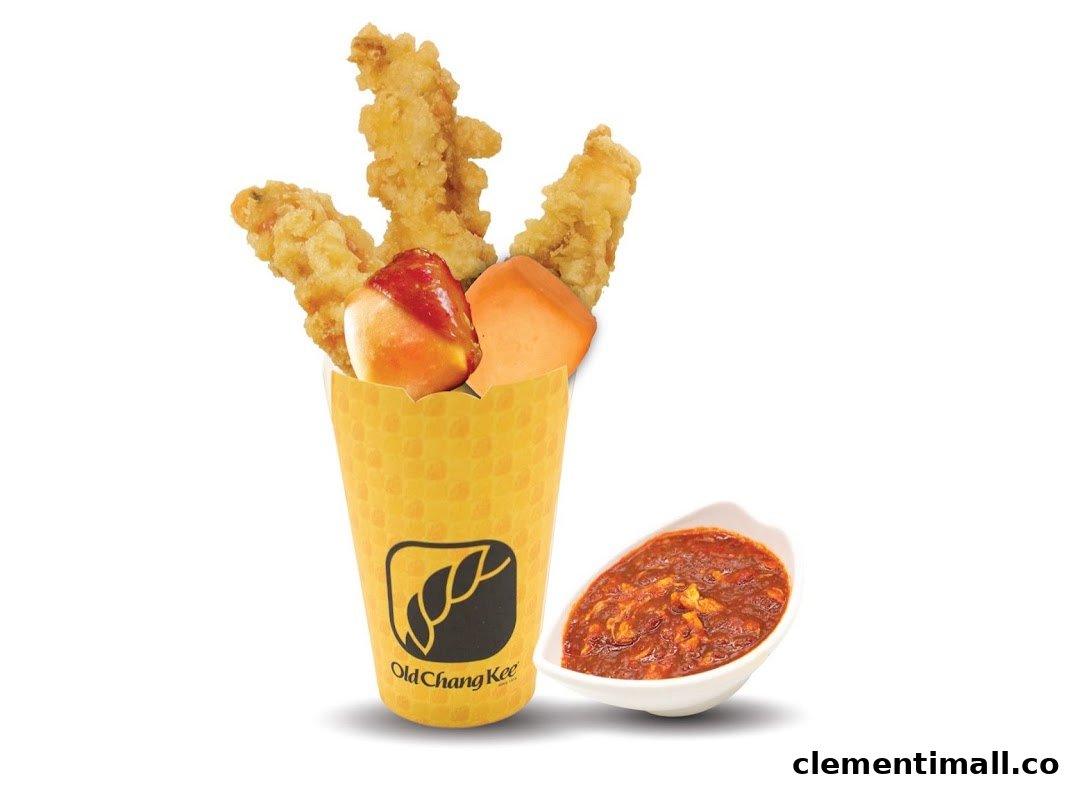 A yellow cup filled with fried snacks, including chicken and a fishball, with a side of chili sauce.