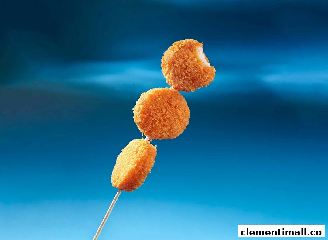 Three golden-fried items on a skewer against a vibrant blue background, one with a bite taken.