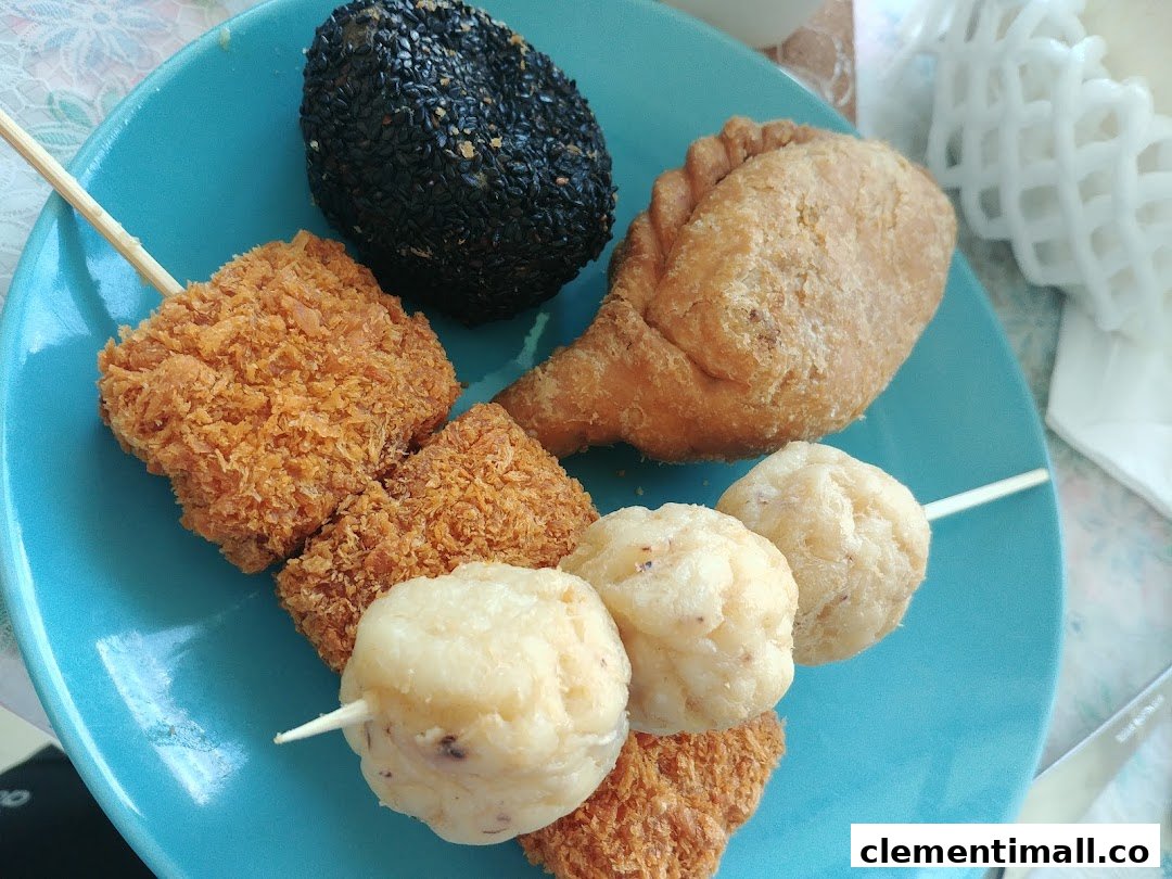 A vibrant blue plate showcasing a variety of Old Chang Kee's popular fried snacks, including curry puffs and fish balls.