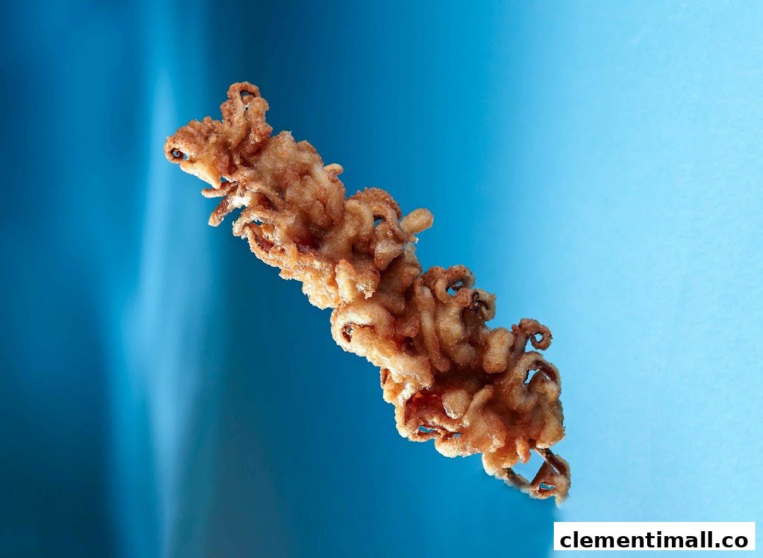 A close-up of golden-brown fried calamari or squid tentacles against a vibrant blue background.