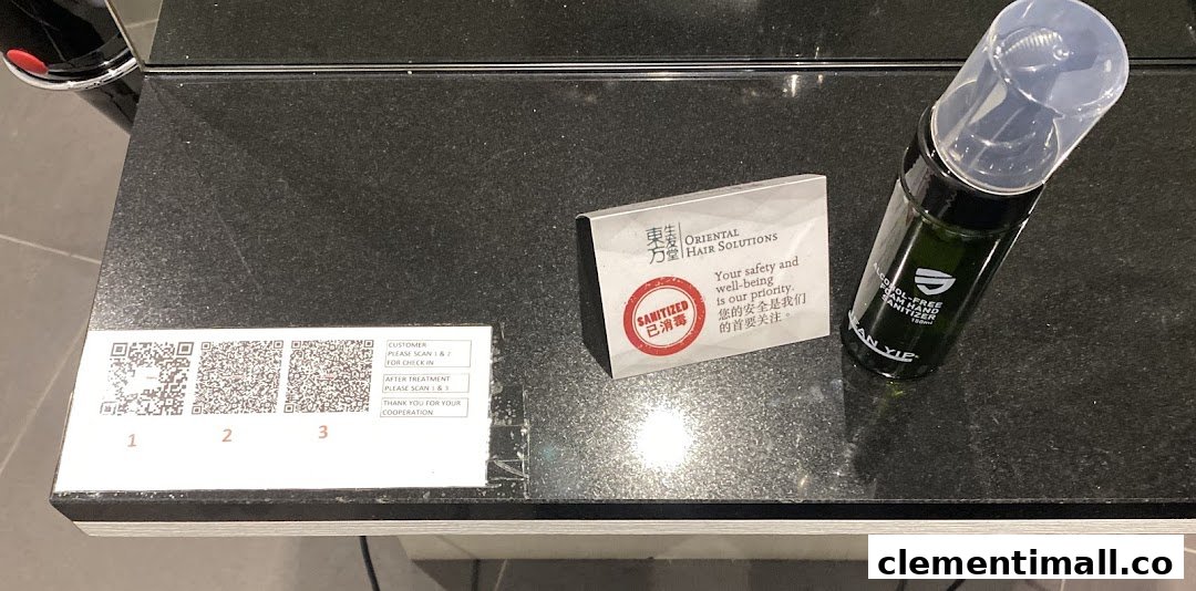 A counter with QR codes for check-in/out, a 'sanitized' sign, and hand sanitizer at Oriental Hair Solutions.