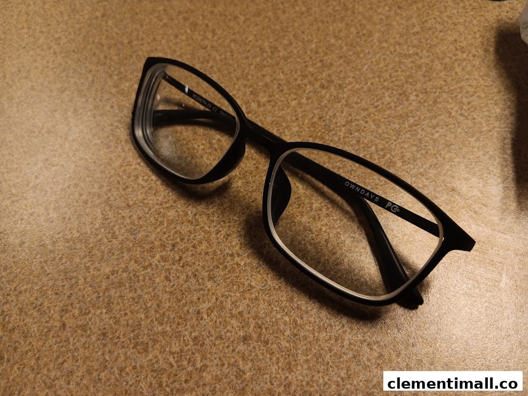 A stylish pair of black OWNDAYS eyeglasses rests on a textured brown surface.