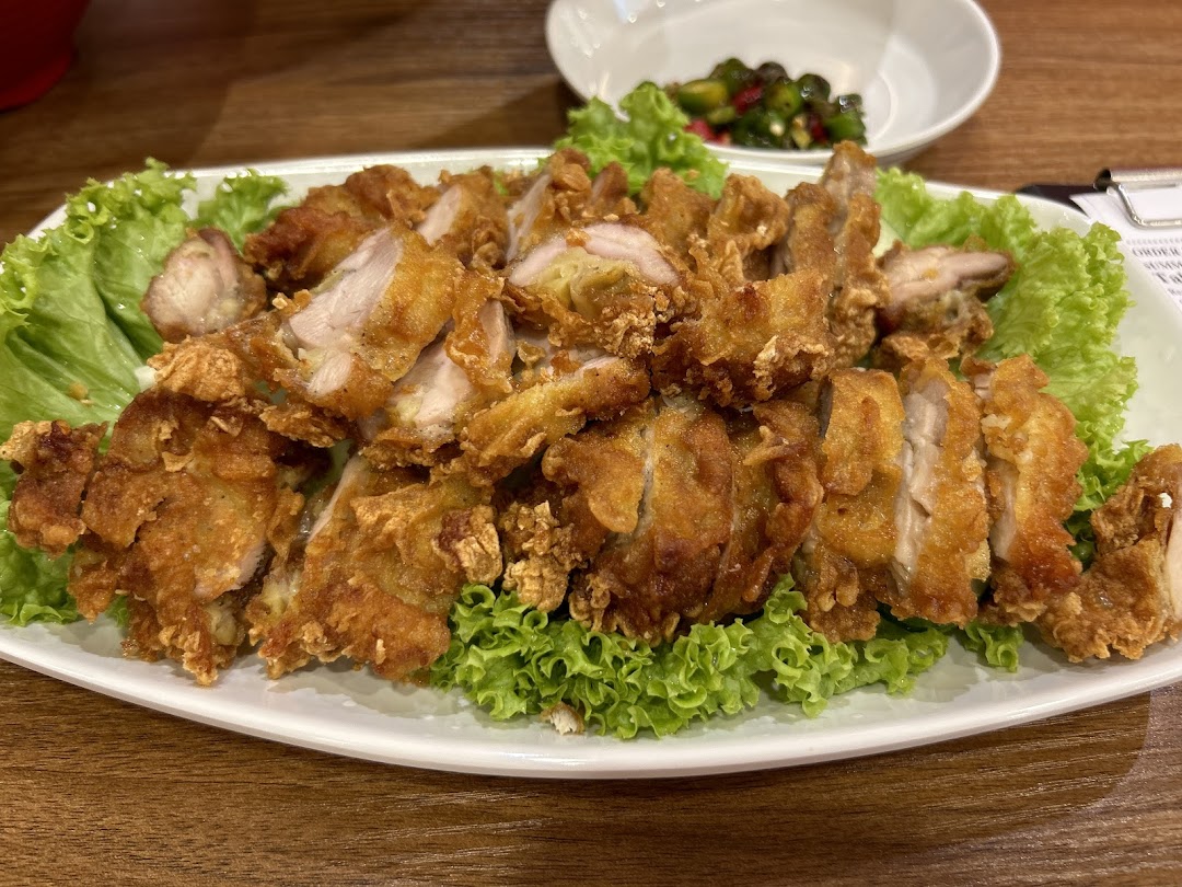 A large platter of crispy fried chicken pieces served on a bed of fresh green lettuce.