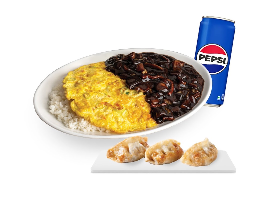 A Korean meal set featuring rice, omelette, black bean sauce, fried dumplings, and a Pepsi can.