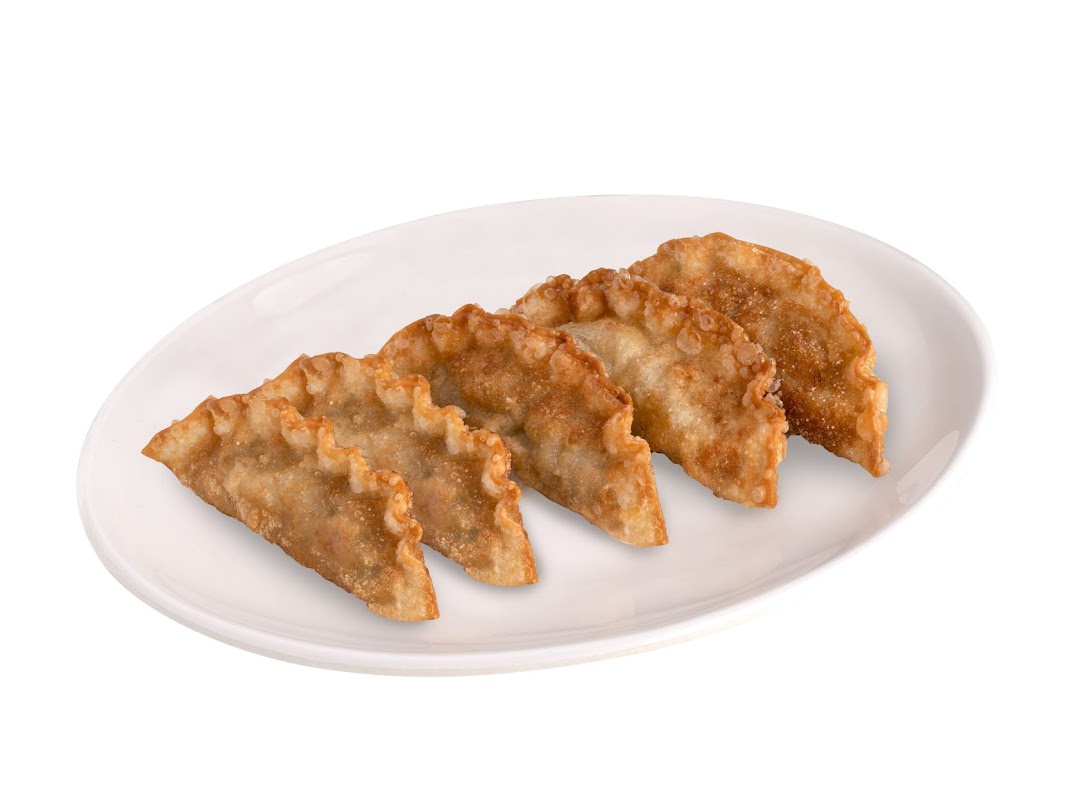 A white plate holds five golden-brown, crispy fried dumplings, likely gyoza or mandu.