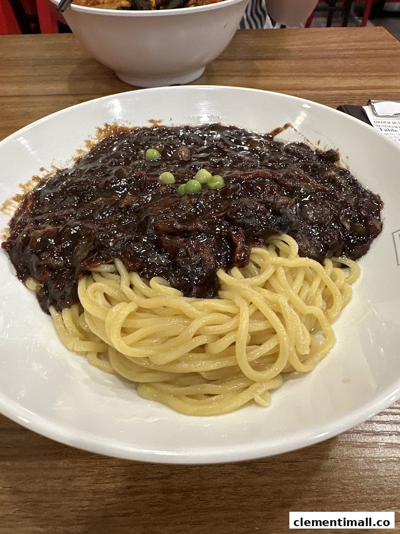 A close-up of a delicious bowl of Jajangmyeon with black bean sauce and noodles.