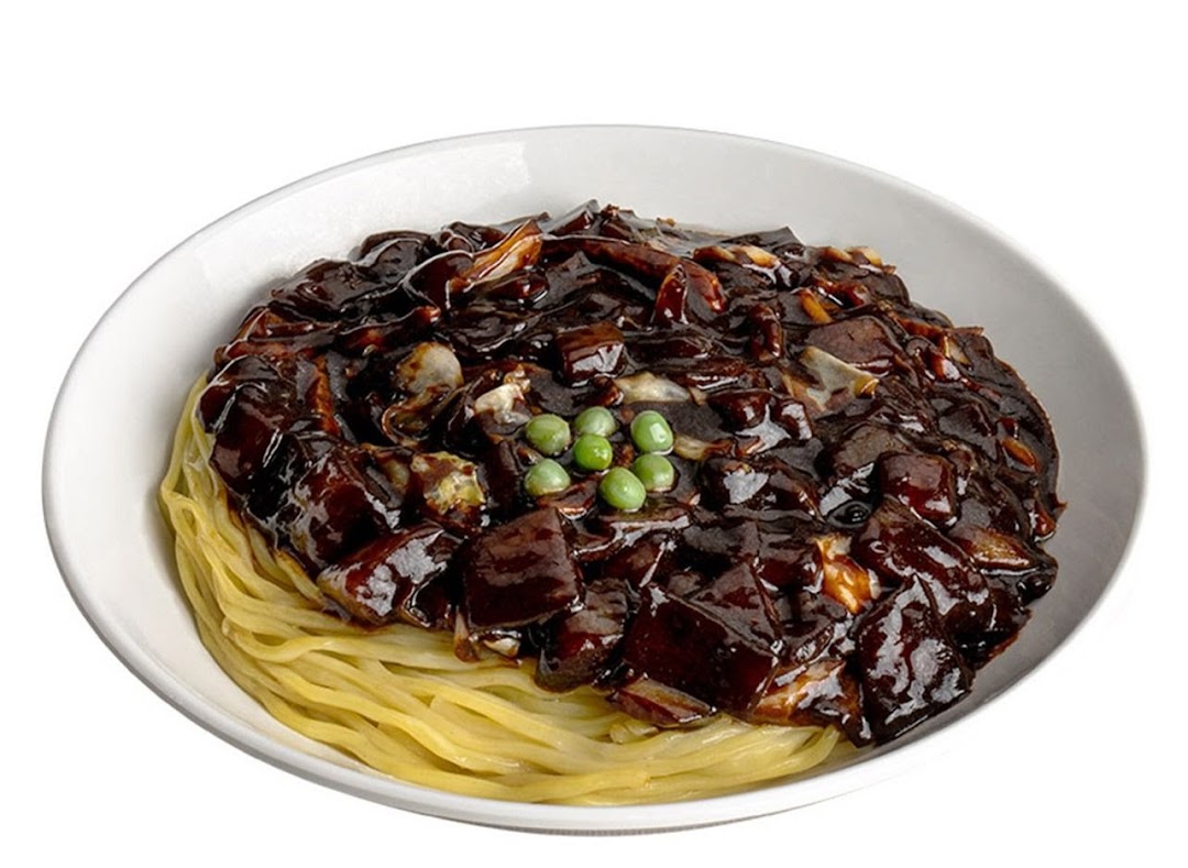 A close-up of a bowl of Jajangmyeon, featuring noodles topped with rich black bean sauce and green peas.
