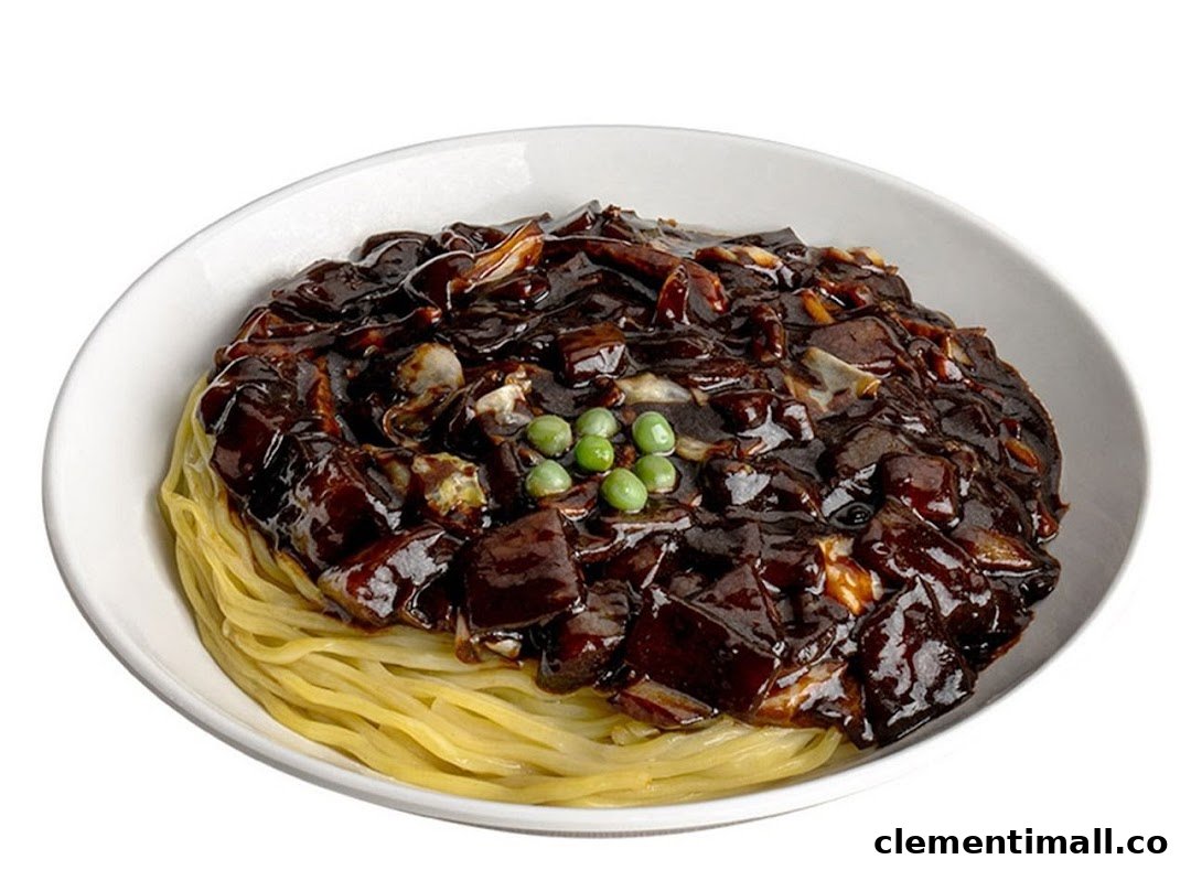 A close-up of a bowl of Jajangmyeon, featuring noodles topped with rich black bean sauce and green peas.