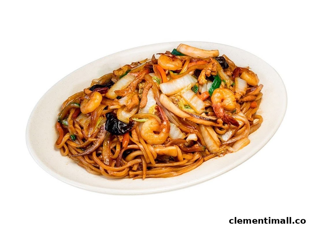 A close-up of a delicious plate of stir-fried noodles with seafood and vegetables.