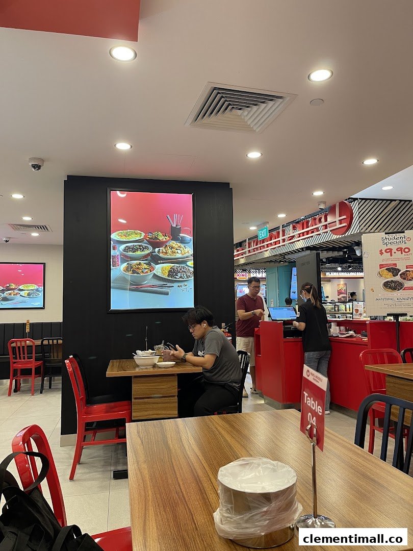 Interior view of Paiks Noodle showing customers dining and a vibrant red counter area.