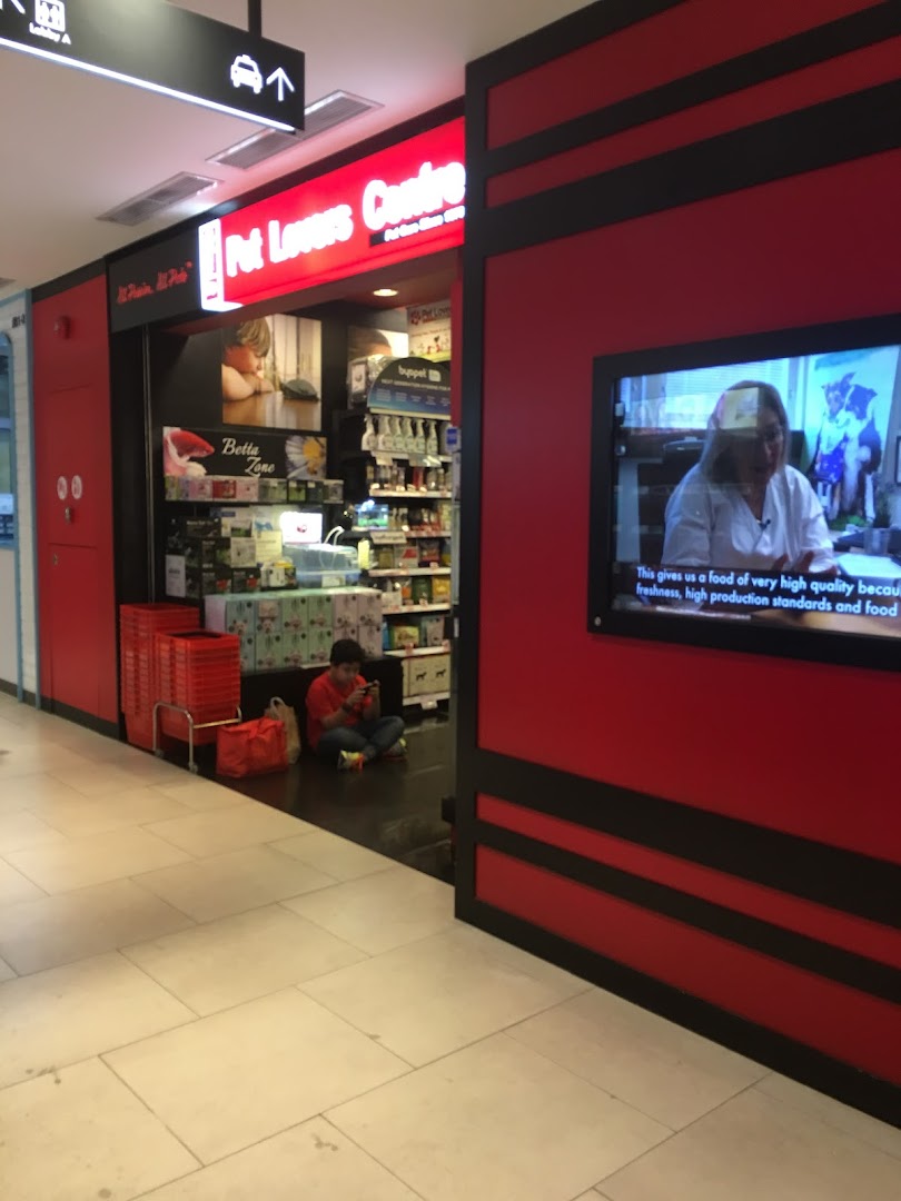 The vibrant red and black storefront of Pet Lovers Centre, showcasing its entrance and interior.
