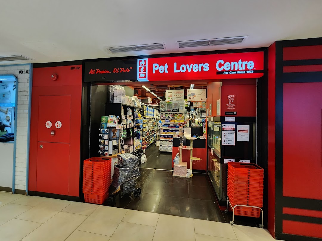 The vibrant red entrance of Pet Lovers Centre, a pet care store, showcasing its interior.