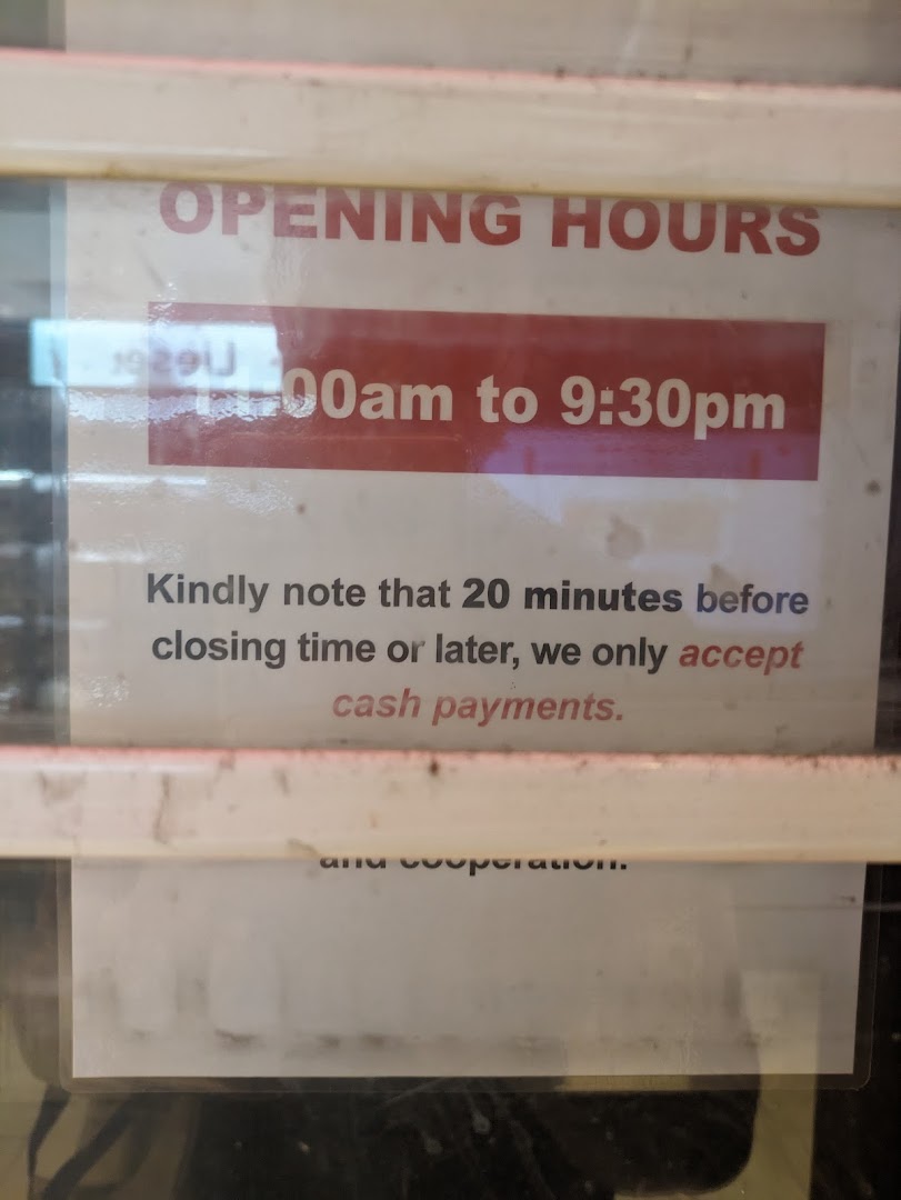 A sign displaying Pet Lovers Centre's opening hours and cash-only payment policy near closing time.
