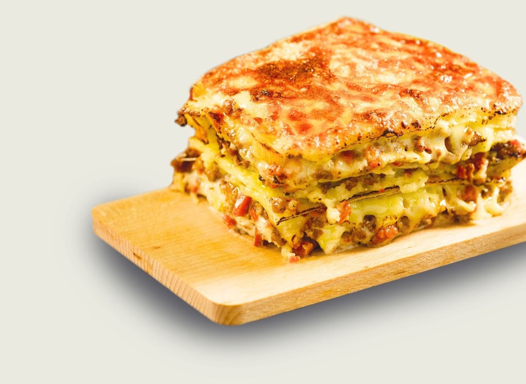 A delicious, multi-layered lasagna with melted cheese and meat sauce on a wooden board.