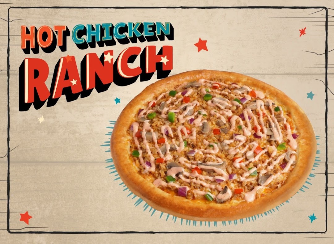 A delicious Hot Chicken Ranch pizza from Pezzo, topped with chicken, vegetables, and ranch sauce.