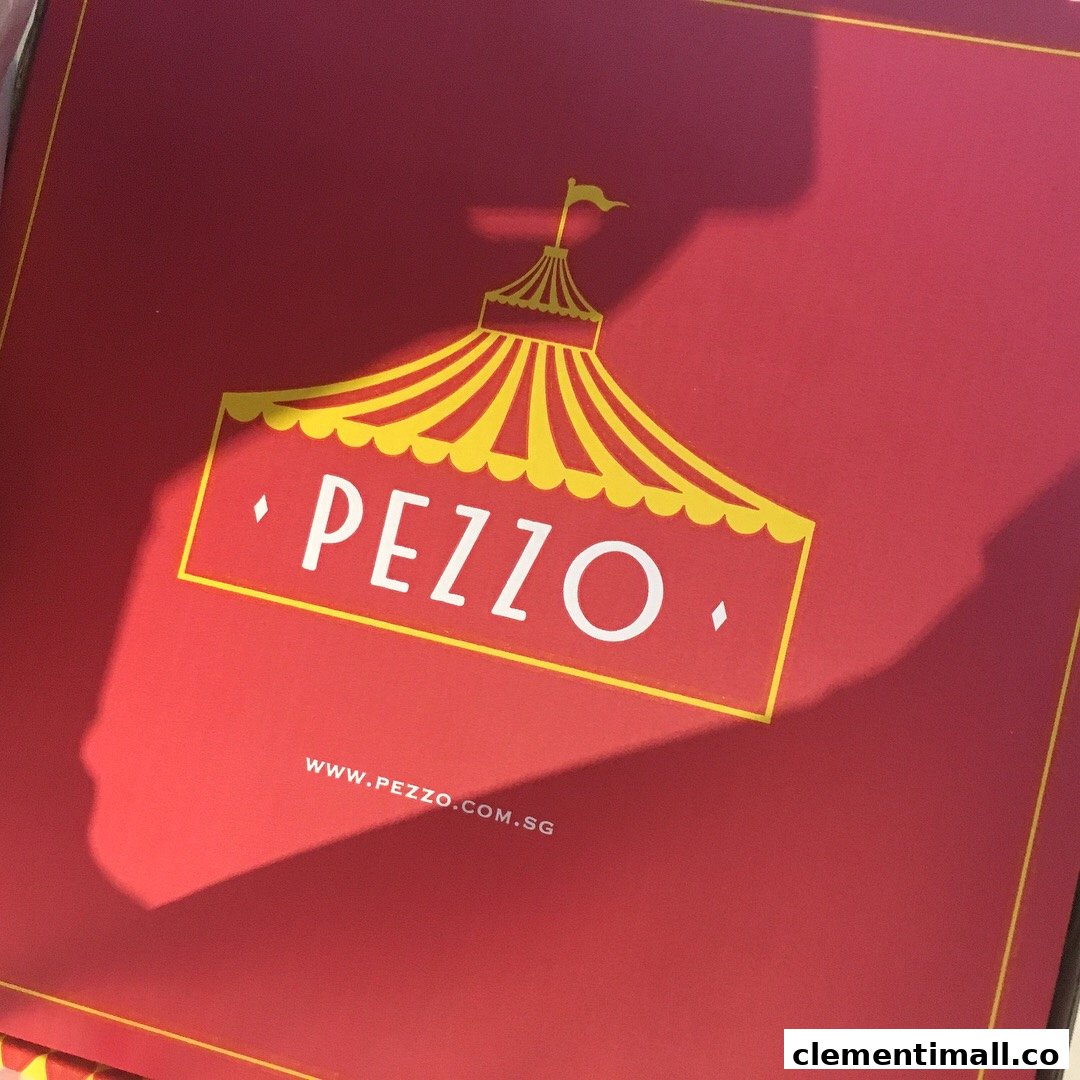 Close-up of a red Pezzo pizza box featuring the brand's distinctive circus tent logo and website.